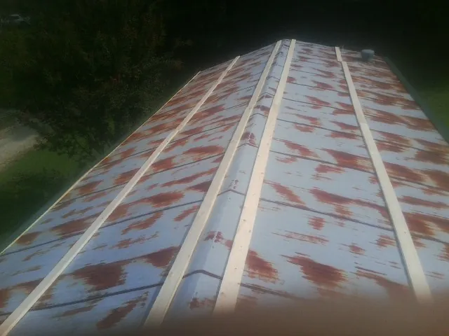 Rusted metal roof panels with new wood purlins before replacement — Storm Damage Roof Repair in Campbellsport by Roofing Brothers