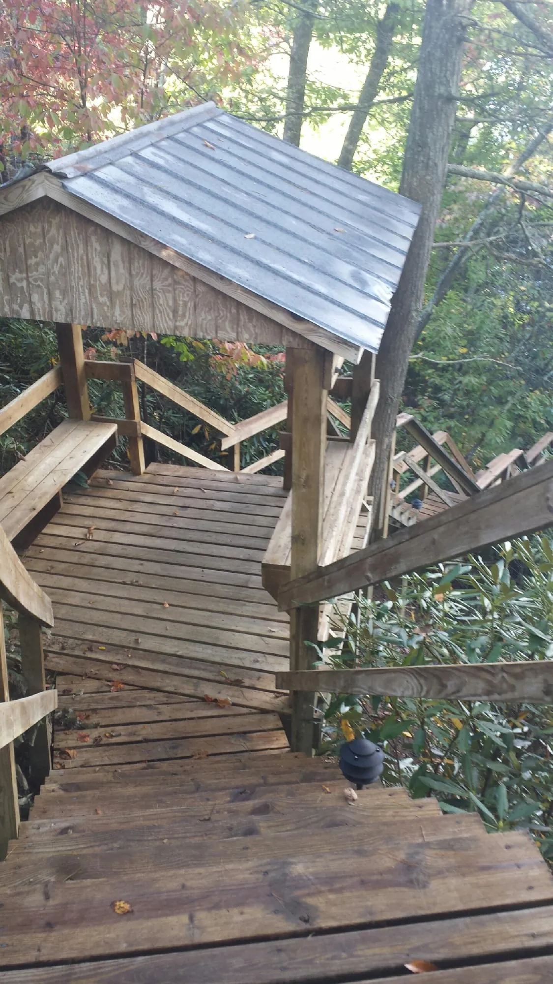 Metal roofed shelter over wooden steps on a wooded walkway — Skylight Repair & Installation work by our crew in Campbellsport