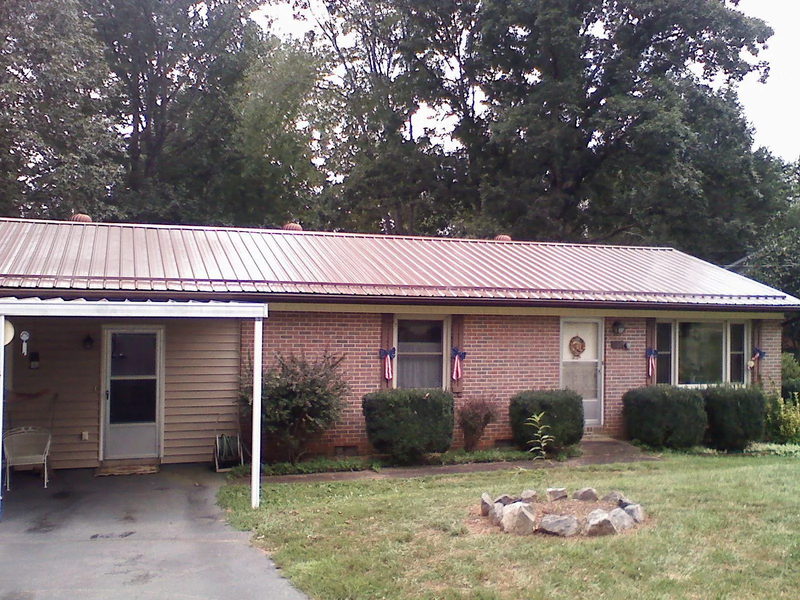 Bronze metal roof and carport on a brick ranch home — Roof Repair work by our crew in Campbellsport